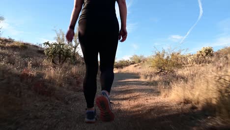 Low-angle-of-woman-walking-on-desert-trail