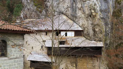 Old-monastery-built-into-Serbian-mountainside-rock,-historic-tourist-destination