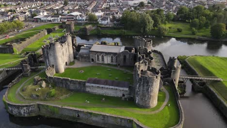 Moated-castle-in-centre-of-Caerphilly-town,-Southern-Wales,-UK,-Aerial-panorama