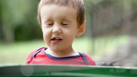 Little-caucasian-boy-making-funny-faces-outdoors,-SLOW-MOTION