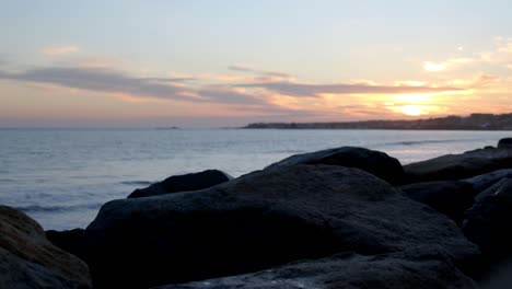 Defocused-sunset-over-the-sea,-orange-sky-in-the-background