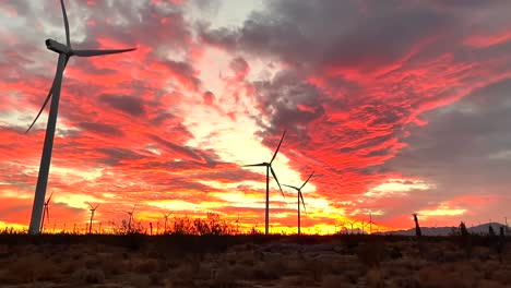 Wind-turbines-in-Californian-desert-turning-at-sunset,-dramatic-skyscape-view
