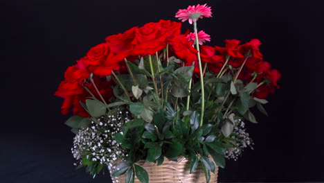 Roter-Rosen--Und-Lilienkorb,-Der-Sich-Mit-Lotus--Und-Gerbera-Dekoration-Auf-Schwarzem-Hintergrund-Dreht