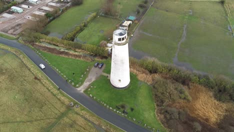 Historic-Leasowe-Lighthouse-maritime-beacon-landmark-aerial-coastal-countryside-Wirral-high-descend-tilting-up-view