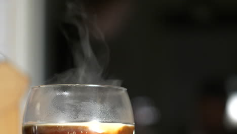 Nahaufnahme-Von-Sahne-In-Zeitlupe,-Die-Dem-Rauchen-Von-Heißem-Kaffeegetränk-Hinzugefügt-Wird