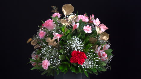 Carnation-arrangement-basket-spinning-in-black-background