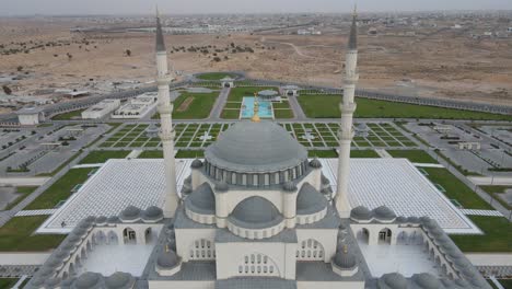 SHARJAH:-Aerial-drone-view-of-Sharjah-Mosque,-the-largest-mosque-in-the-Emirate-of-Sharjah,-United-Arab-Emirates