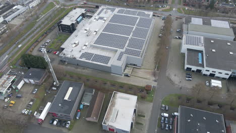 Aerial-tilting-down-to-industrial-rooftop-filled-with-solar-panels