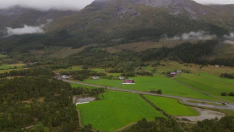 Typical-landscape-in-Western-Norway-with-mountains,-forests,-fields-and-mist