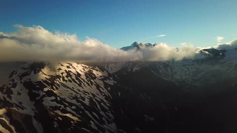 Luftaufnahme-Der-österreichischen-Berge-Schneebedeckte-Gipfel,-Die-Die-Wolken-Erreichen