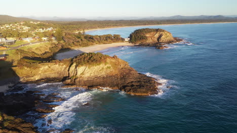 Lowering-drone-shot-of-Scotts-Head-beach-and-rocky-coastline-in-Australia