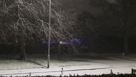 Peaceful-snowfall-across-street-light-at-night-seasonal-town-neighbourhood-winter-scene