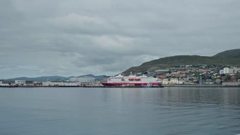 Cruise-Ship-Docked-On-Pier-In-Norway-With-Calm-Waters-In-Foreground