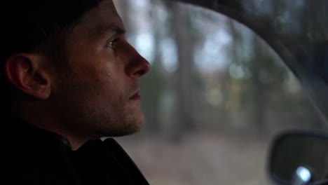 Profile-of-the-handsome-face-of-a-young-man-as-he-drives-through-the-forest-on-a-special-trip