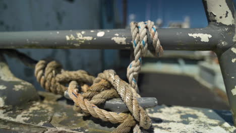 Rope-Knot-Tied-To-Metal-Pole-On-Old-Boat---close-up