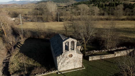 Circular-aerial-view-of-an-abandoned-church-in-the-middle-of-the-fields-on-the-mountains