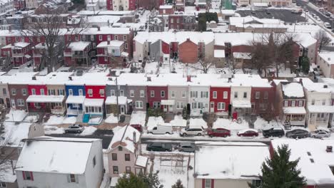 Aerial-truck-shot-of-colorful-rowhomes-in-winter-snow