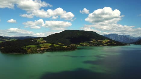 Aerial-view-of-mountain-lake-Mondsee-along-the-shoreline-of-Sankt-Lorenz,-Austria