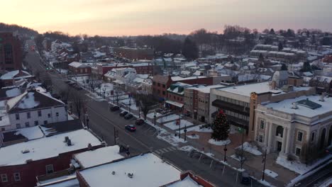 Establishing-aerial-of-town-in-winter-snow-at-sunrise,-sunset