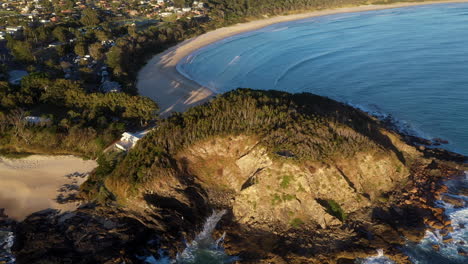 Rotating-drone-shot-of-rocky-outcropping-in-the-ocean-at-Scotts-Head-beach-in-Australia