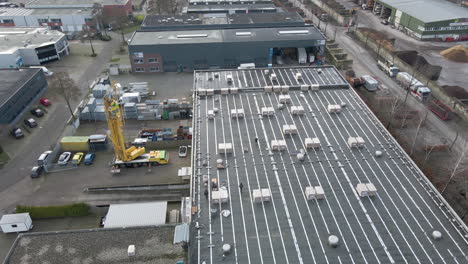 Aerial-of-construction-workers-walking-on-rooftop-on-industrial-site