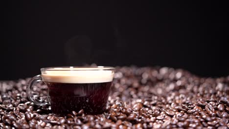 Coffee-cup-with-steam-next-to-coffee-beans-on-dark-background-in-Slow-motion-HD