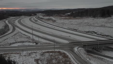 Empty-Highway-Covered-With-Snow-In-Winter---Cold-Sunrise-Scenery---aerial-drone