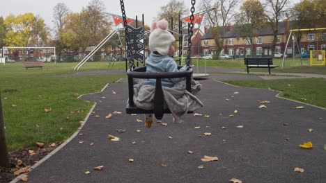 Baby-girl-on-swing-in-desolated-playground-due-to-Covid19,-England
