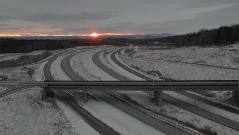 Malerischer-Blick-Auf-Autobahnen-In-Winterlandschaft-Mit-Autos,-Die-Bei-Sonnenaufgang-Fahren