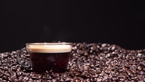 Kaffeetasse-Mit-Dampf-In-Kaffeebohnen-Mit-Schwarzem-Hintergrund-In-4k