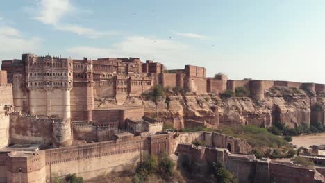 Mehrangarh-Fort,-Das-über-Der-Himmelslinie-Von-Jodhpur,-Rajasthan,-Indien-Steht---Luftpanoramaumlaufbahnaufnahme