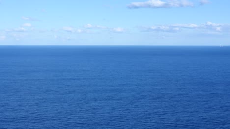 Vista-Panorámica-Del-Océano-Azul-Sereno-Bajo-Un-Cielo-Despejado-Con-Nubes