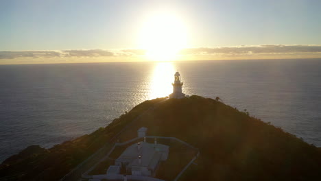 Cinematic-rotating-into-the-sun-drone-shot-of-Smoky-Cape-Lighthouse