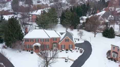 Large-brick-mansion-covered-in-winter-snow-and-decorated-for-Christmas-holidays