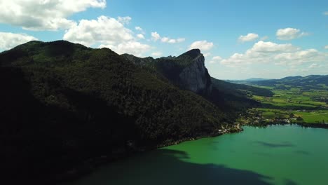 Aerial-view-of-mountain-lake-Mondsee-along-the-coastline-of-Sankt-Lorenz,-Austria
