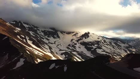 Luftaufnahme-Der-österreichischen-Berge-Schneebedeckte-Gipfel,-Die-Die-Wolkenlandschaft-Berühren