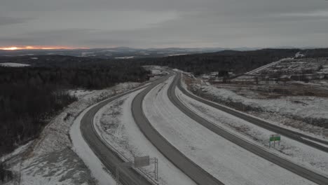 Drone-Flying-On-Empty-Country-Roads-In-Winter-Landscape-During-Sunrise