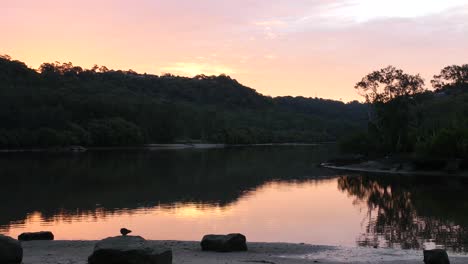 Dramatic-Sunset-Sky-Over-Hills-Reflected-On-Serene-Water-Of-Woronora-River,-Australia