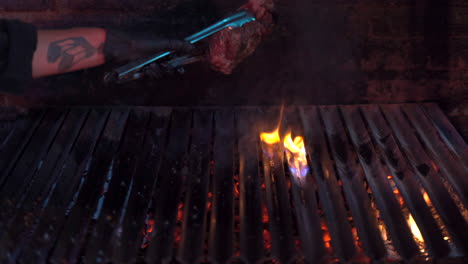 Grillchef-Schlägt-Das-Steak-Auf-Den-Grill-Und-Erzeugt-Eine-Flamme