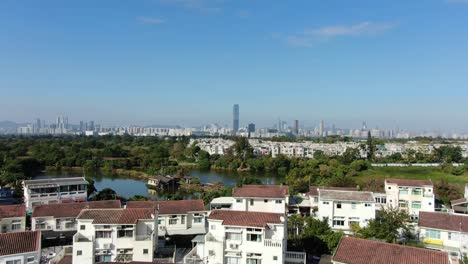 Grenzlinie-Zwischen-Hong-Kong-Und-Shenzhen-über-Hong-Kong-Ländliche-Häuser-Mit-Shenhzen-Skyline-Am-Horizont,-Luftbild