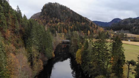 Scenic-drone-footage-of-a-forest-river-and-hills-in-Autumn