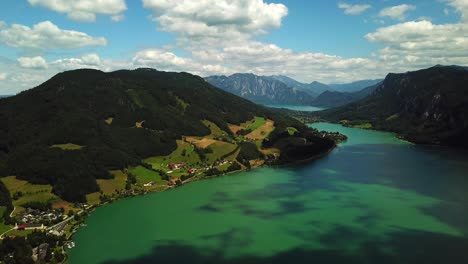 Aerial-view-over-mountain-lake-Mondsee-along-the-coastline-of-Sankt-Lorenz,-Austria