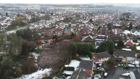 Snowy-aerial-village-residential-neighbourhood-Winter-frozen-North-West-houses-and-roads-descending-across-building-site