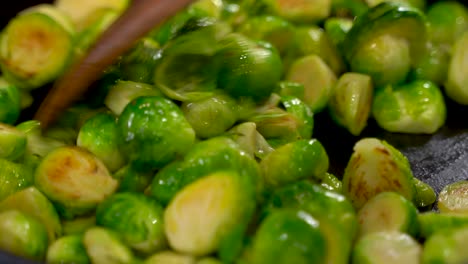 Cooking-Roasted-Sautéed-Brussels-Sprouts-in-a-Cast-Iron-Pan-Skillet---Stirring-and-Mixing-with-a-Wooden-Spatula---Wide-Shot