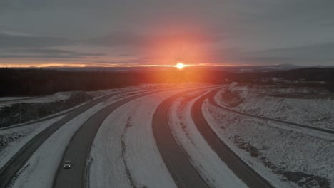 Fahrt-Durch-Die-Autobahn-In-Winterlandschaft-Mit-Majestätischem-Sonnenaufgang-Im-Hintergrund