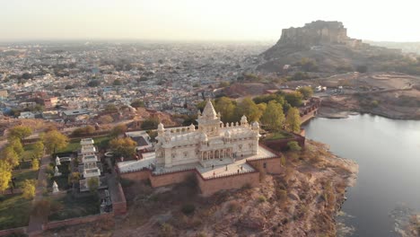 Aerial-footage-of-a-historical-stone-palace-before-the-vast-city-of-Jodhpur,-India