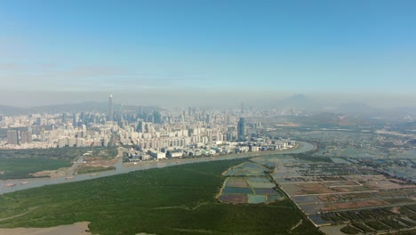 Línea-Fronteriza-De-Hong-Kong-Y-Shenzhen-Sobre-Casas-Rurales-De-Hong-Kong-Con-El-Horizonte-De-Shenhzen-En-El-Horizonte,-Vista-Aérea