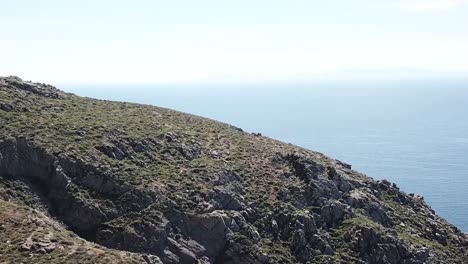 Aerial-Drone-Mykonos-Greece-Pan-Up-Cliffside-Beach