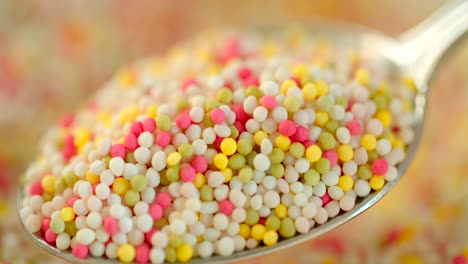 Close-up-shot-of-taking-a-spoon-full-of-colorful-sugar-sprinkles-dots