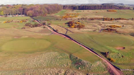 Scottish-links-golf-course-from-the-air-with-a-path-cutting-through-on-a-sunny-day